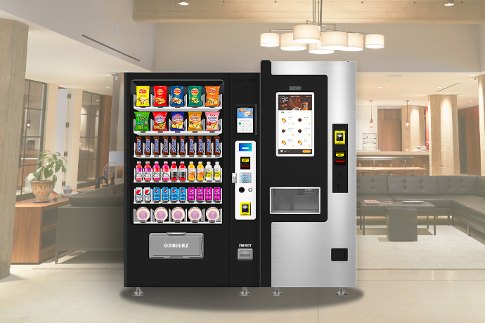 Pracownik biurowy korzystający z samoobsługowego kącika kawowego i automatu z przekąskami.